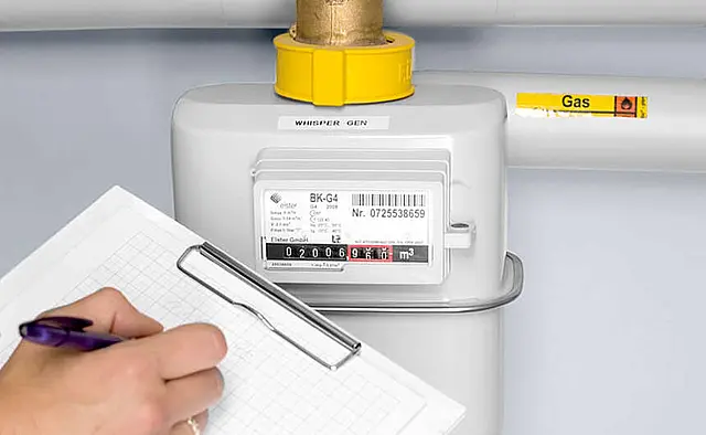 Gas meter with reading display, yellow connector, and a hand noting the values