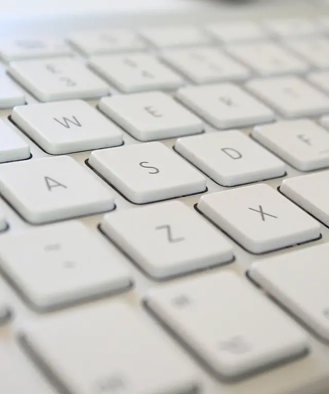 Weiße Computertastatur in Nahaufnahme mit Fokus auf die Tasten W, A, S, D