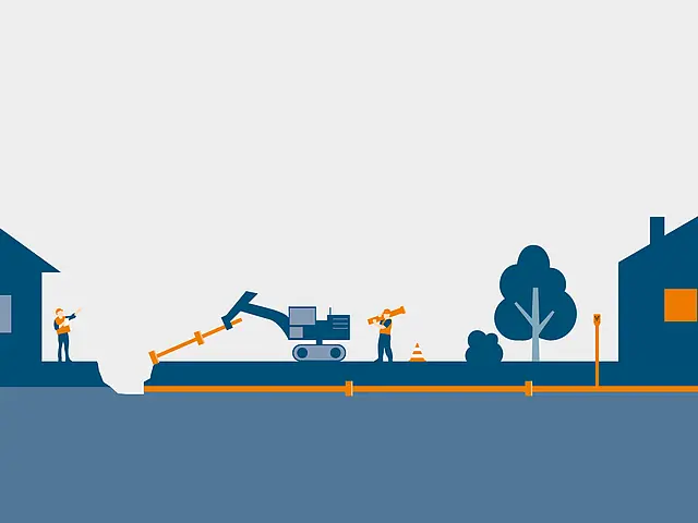 Bauarbeiter verlegen zwischen zwei Wohnhäusern mit Bagger und Werkzeugen eine orangefarbene Leitung im Erdreich.